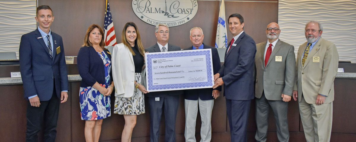 Jim Troiano and the City of Palm Coast Commissioners with a cost-share check