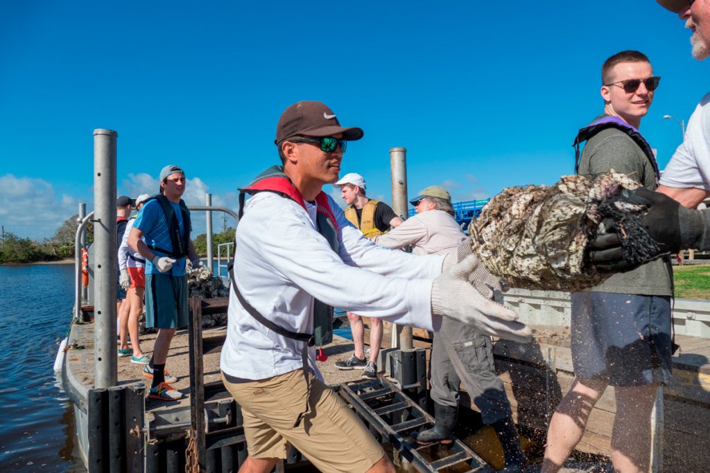20180221-095336 Volunteers loading bags of oyster shells on a barge