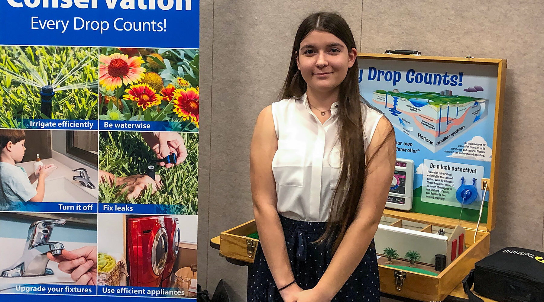 Student H2O Hero Madison Aprandini standing with a water conservation display