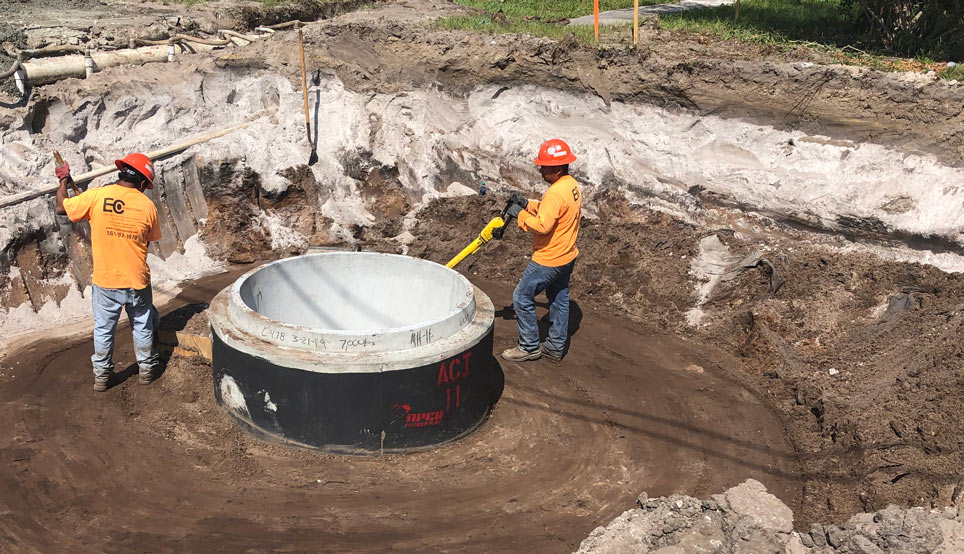 Construction workers installing sewer pipes