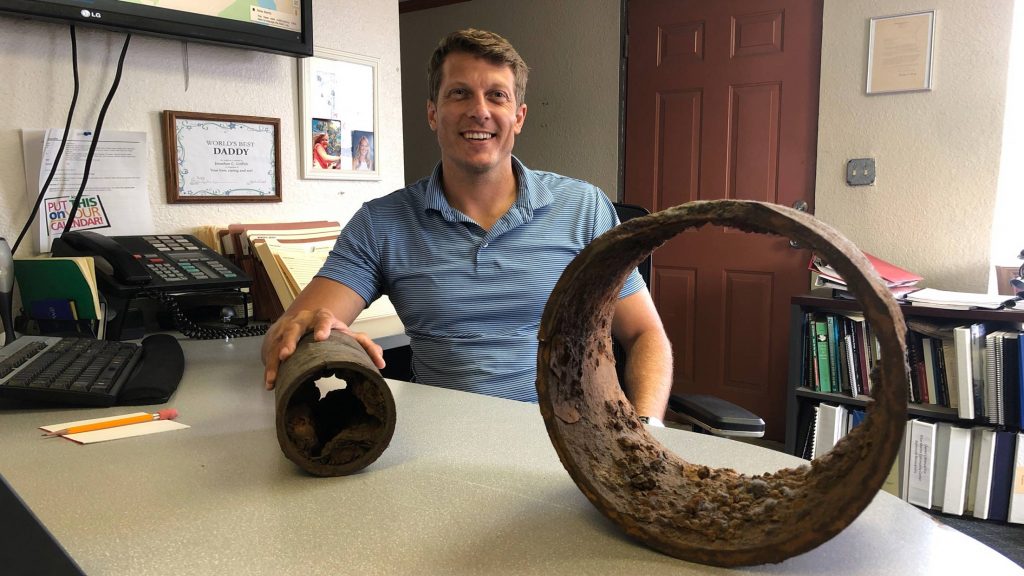 Jonathan Griffith displays a piece of cast iron pipe in his office