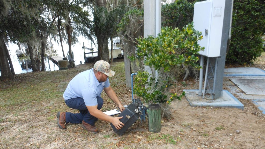 A Clermont Utilities worker repairs a homeowner’s water meter.