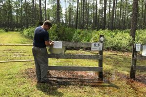 District employee putting a sign up on a fence