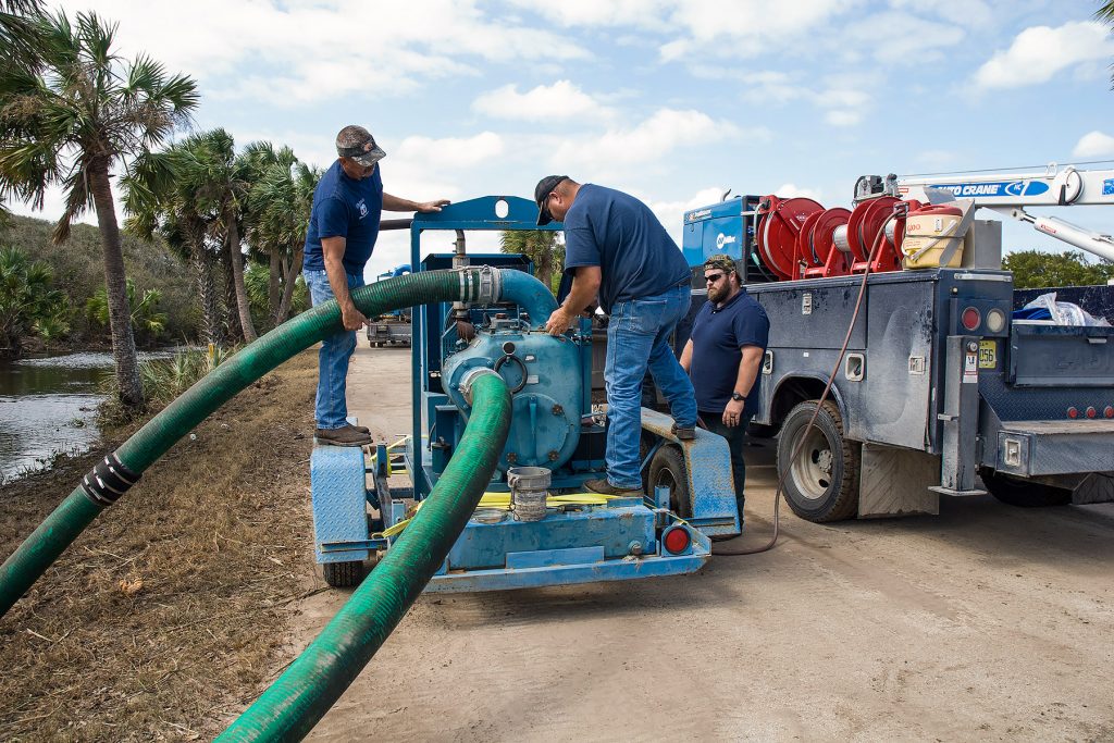 People working with a large water pump