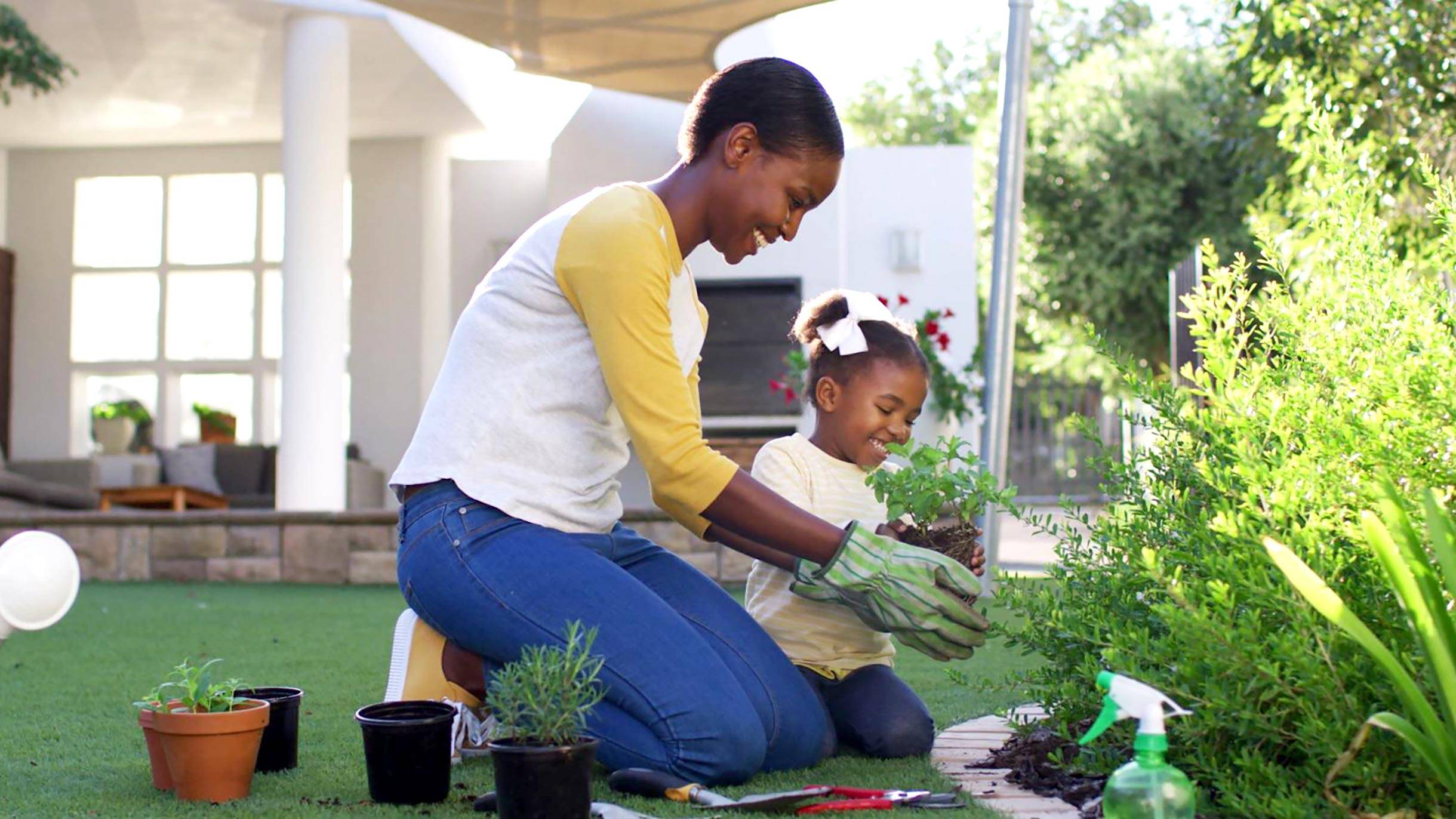Mother and daughter planting in a garden