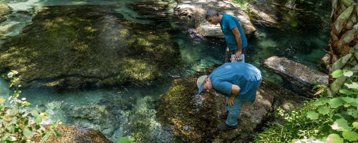 Two men inspecting a spring